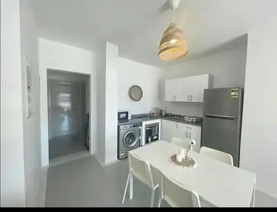 a kitchen with a table and chairs and a refrigerator at Spacious 2 BD with crystal Lagoon access in Gouna in Hurghada