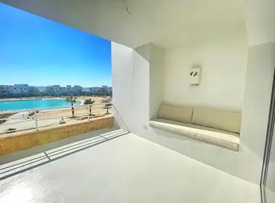a room with a window with a view of the beach at Spacious 2 BD with crystal Lagoon access in Gouna in Hurghada