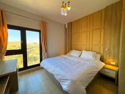 a bedroom with a large bed with a large window at ALDAU LaLa in Hurghada