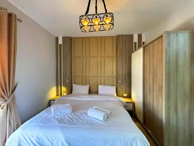 a bedroom with a large white bed with a chandelier at ALDAU LaLa in Hurghada