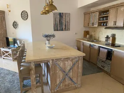 a kitchen with a wooden table and a counter top at vintage sea view apartment in Hurghada