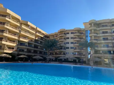 a swimming pool in front of a large building at vintage sea view apartment in Hurghada