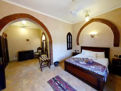 a bedroom with a large bed and an archway at Riverbank House in Luxor