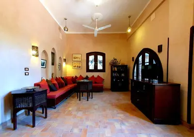 a living room with a red couch and tables at Riverbank House in Luxor