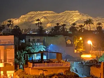 a picture of a house with a mountain in the background at Riverbank House in Luxor