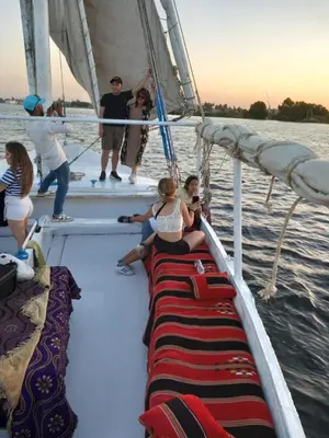 a group of people on a sail boat in the water at فلوكة نيلية in Luxor