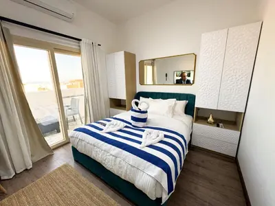 a bedroom with a blue and white bed with a mirror at Arаbian Suites by Imperial in Hurghada