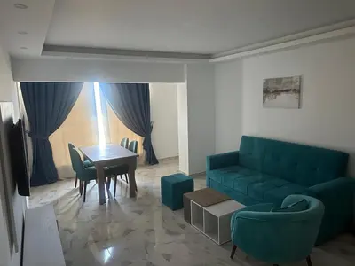 a living room with a blue couch and a table at Sea view chalet hurghada in Hurghada
