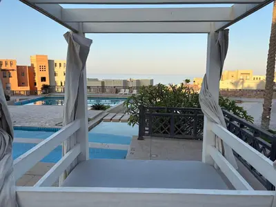a room with a bed and a view of a pool at Cozy Suite in Azzurra Resort Sahl Hasheesh 95 SqM in Hurghada