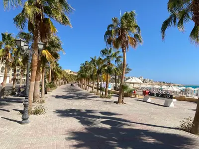 a street lined with palm trees on a beach at Cozy Suite in Azzurra Resort Sahl Hasheesh 95 SqM in Hurghada