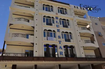 a large white building with blue windows at Boho Oasis - Studio Hurghada Red Sea in Hurghada