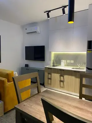a kitchen with a dining table and a kitchen with a counter at Aqva infinity resort c102 in Hurghada