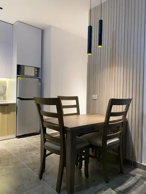 a kitchen with a wooden table with chairs and a refrigerator at Aqva infinity resort c102 in Hurghada
