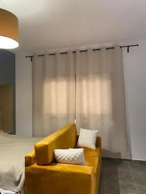 a yellow couch sitting in front of a bed at Aqva infinity resort c102 in Hurghada
