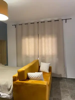 a yellow couch sitting in front of a bed at Aqva infinity resort c102 in Hurghada