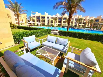 a patio with chairs and a table next to a pool at El gouna mangroovy M3-3D-01 ground floor in Hurghada