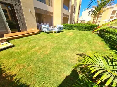 a yard with chairs and a lawn in front of a building at El gouna mangroovy M3-3D-01 ground floor in Hurghada