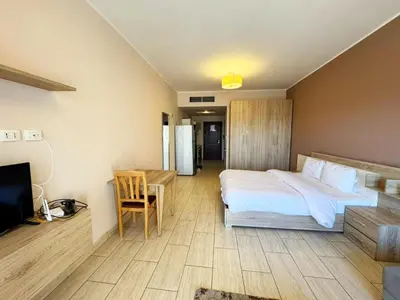 a bedroom with a bed and a desk and a television at Apartment Aldau in Hurghada