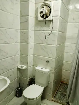 a white bathroom with a toilet and a sink at Taiba View Studio in Hurghada