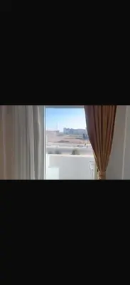 a window with a curtain and a view of an airport at 1 bedroom apartment hurghada in Hurghada
