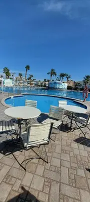 two tables and chairs next to a swimming pool at Minaland Beach Resort & Aquapark in Hurghada