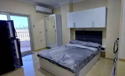 a bedroom with a bed and a large window at Beachfront Studio Hurghada in Hurghada
