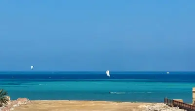 a view of the ocean with two sail boats in the water at Beachfront Studio Hurghada in Hurghada