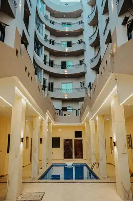 a large building with a swimming pool in front of a building at Beachfront Studio Hurghada in Hurghada