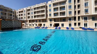 a large swimming pool in front of a large building at Hurghada HUB Resort in Hurghada