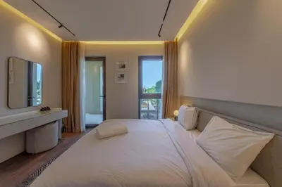a bedroom with a large white bed and a television at Serene Lakeview Escape 2BR at Cyan ElGouna in Hurghada