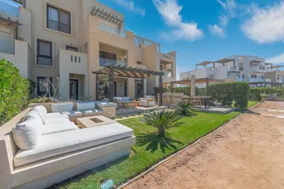 a white couch sitting in a yard in front of a building at Serene Lakeview Escape 2BR at Cyan ElGouna in Hurghada
