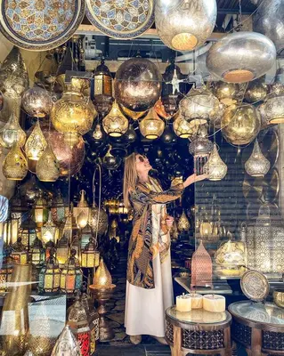 a woman standing in front of a display of lights at Al Wadi Hotel in Al Aqālitah