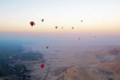 a group of hot air balloons flying in the sky at Al Wadi Hotel in Al Aqālitah