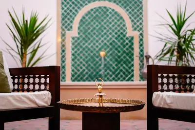 a table in between two chairs and a table between two chairs at Al Wadi Hotel in Al Aqālitah