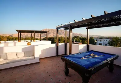 a patio with a couch and a table on a roof at Al Wadi Hotel in Al Aqālitah