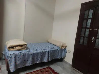 a small bed in a corner of a room at الاقصر امتداد ش التليفزيون in Luxor