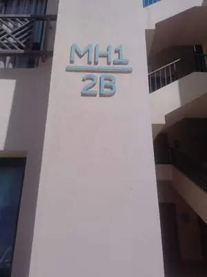 a sign on the side of a building with the number at Hurghada Apartment Makadi Lagon & Swimming Pools Free in Hurghada