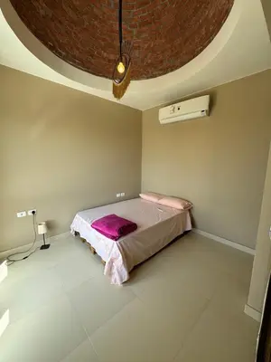 a bedroom with a bed in a room with a ceiling at Hurghada Apartment Makadi Lagon & Swimming Pools Free in Hurghada