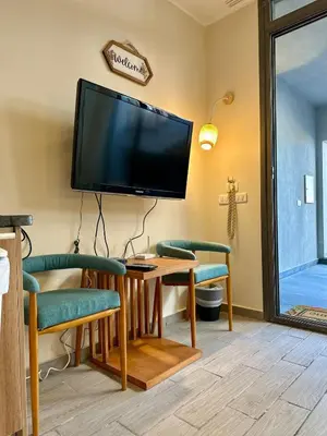 a living room with a tv and a table and chairs at Bali Gouna 1 bed - heated pool in Hurghada