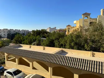 a building with cars parked in a parking lot at Aldau Maxico in Hurghada