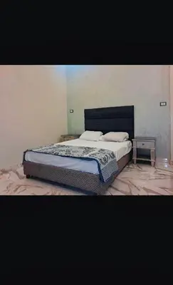 a bedroom with a bed and a side table at Nile palace apartment in Luxor