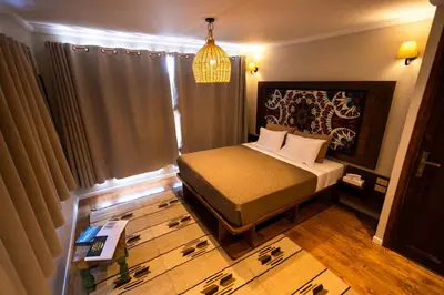 a small bedroom with a bed and a window at Escaleeh Dahabiya Tranquil sailing in Jazīrat Suhayl