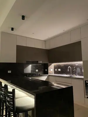 a kitchen with a black counter and some chairs at Luxurious 3Bd Living Awaits in El Gouna in Hurghada