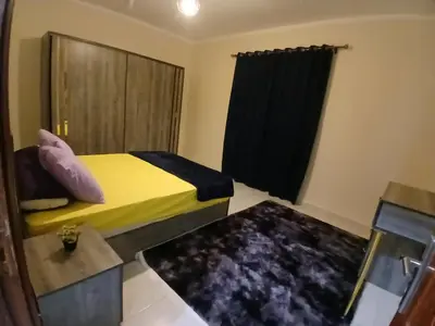 a small bedroom with a yellow bed and a window at Yulla apartment in Hurghada