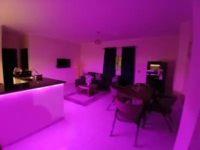 a living room with purple lighting and a couch at Yulla apartment in Hurghada