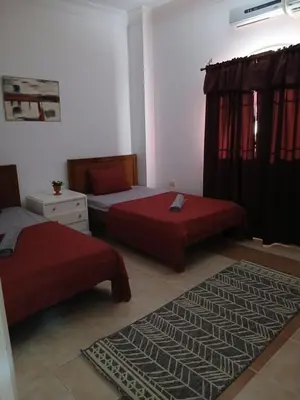 a bedroom with two beds and a rug at Villa yulla in Hurghada
