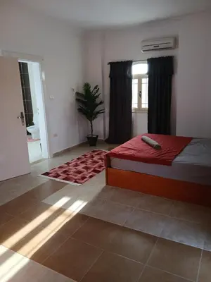 a bedroom with a bed and a window and a rug at Villa yulla in Hurghada