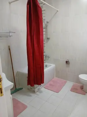a bathroom with a red shower curtain and a toilet at Villa yulla in Hurghada