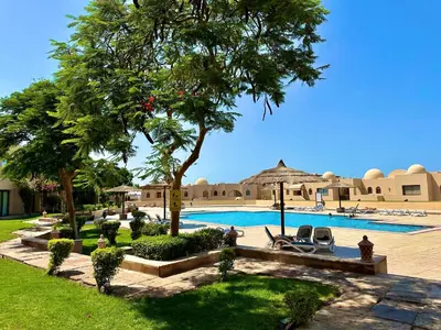 a resort with a swimming pool and trees and chairs at Palm View Paradise-Downtown Hurghada in Hurghada