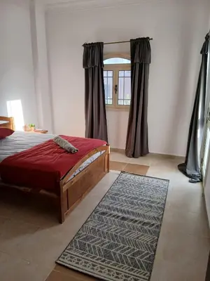 a bedroom with a red bed and a window at Cozy Villa in Hurghada